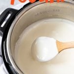 Wooden spoon stirring homemade yogurt in an Instant Pot. Text overlay says "Instant Pot Homemade Yogurt"