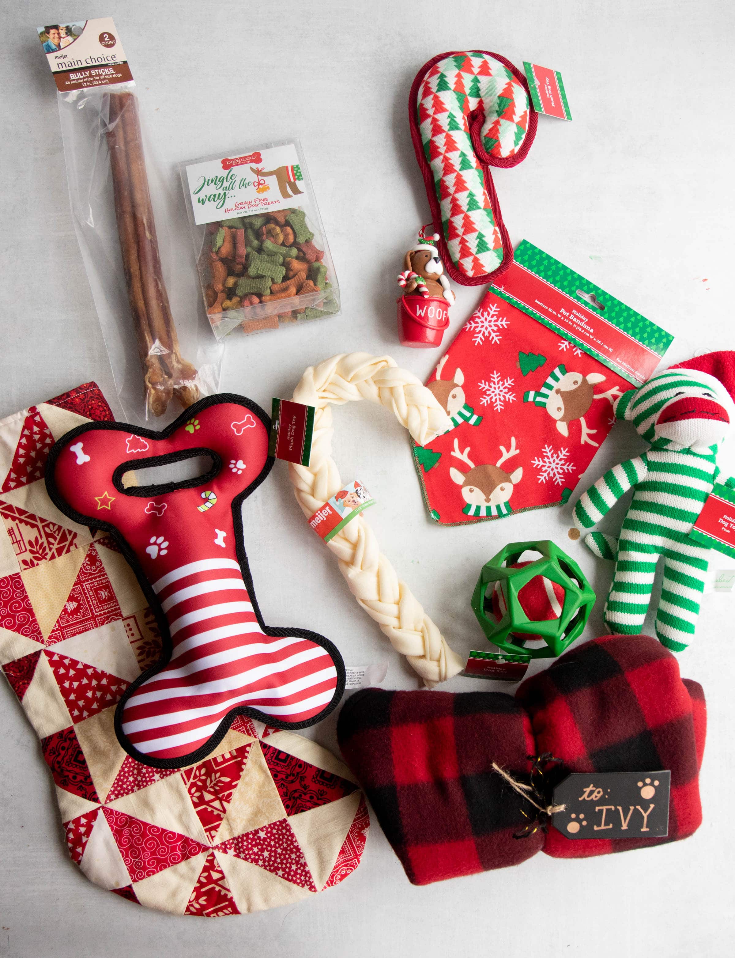 Stocking fillers for a dog - toys, treats, a red and white stocking, and a custom dog coat