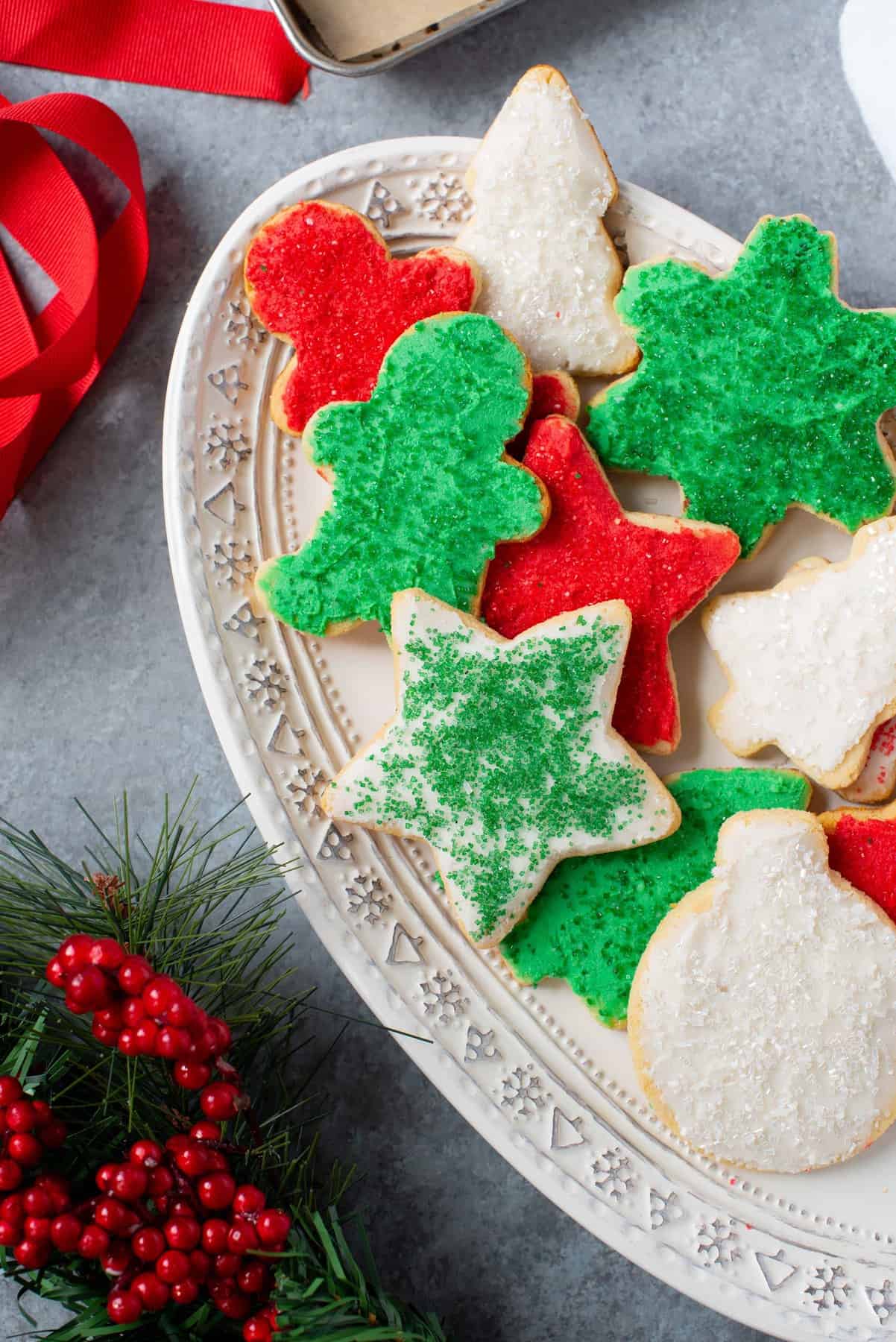 Grain-Free Paleo Sugar Cookies with Coconut Butter Frosting and Christmas sprinkles on a white platter