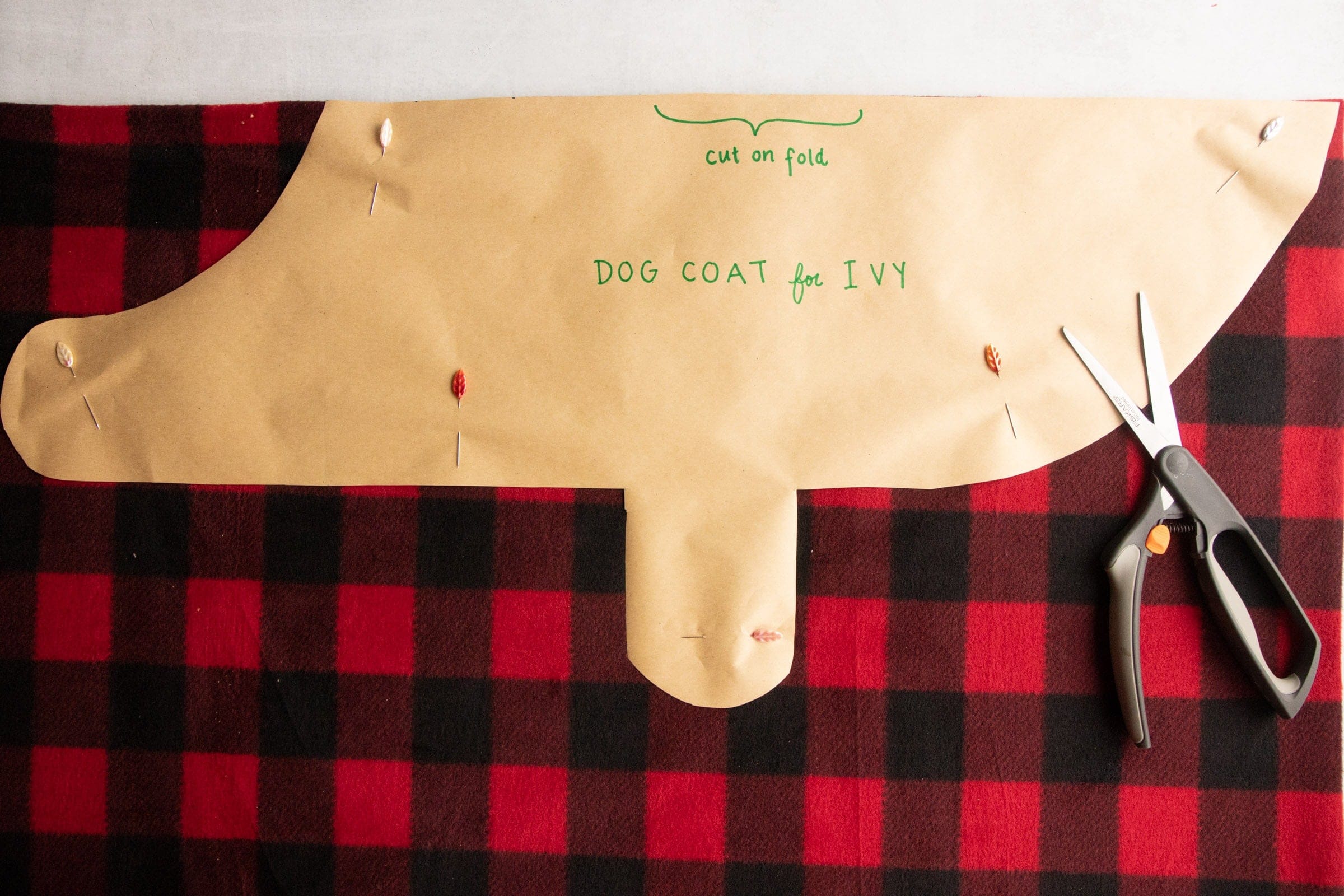 Pattern labeled "Dog Coat for Ivy" pinned to a piece of fleece