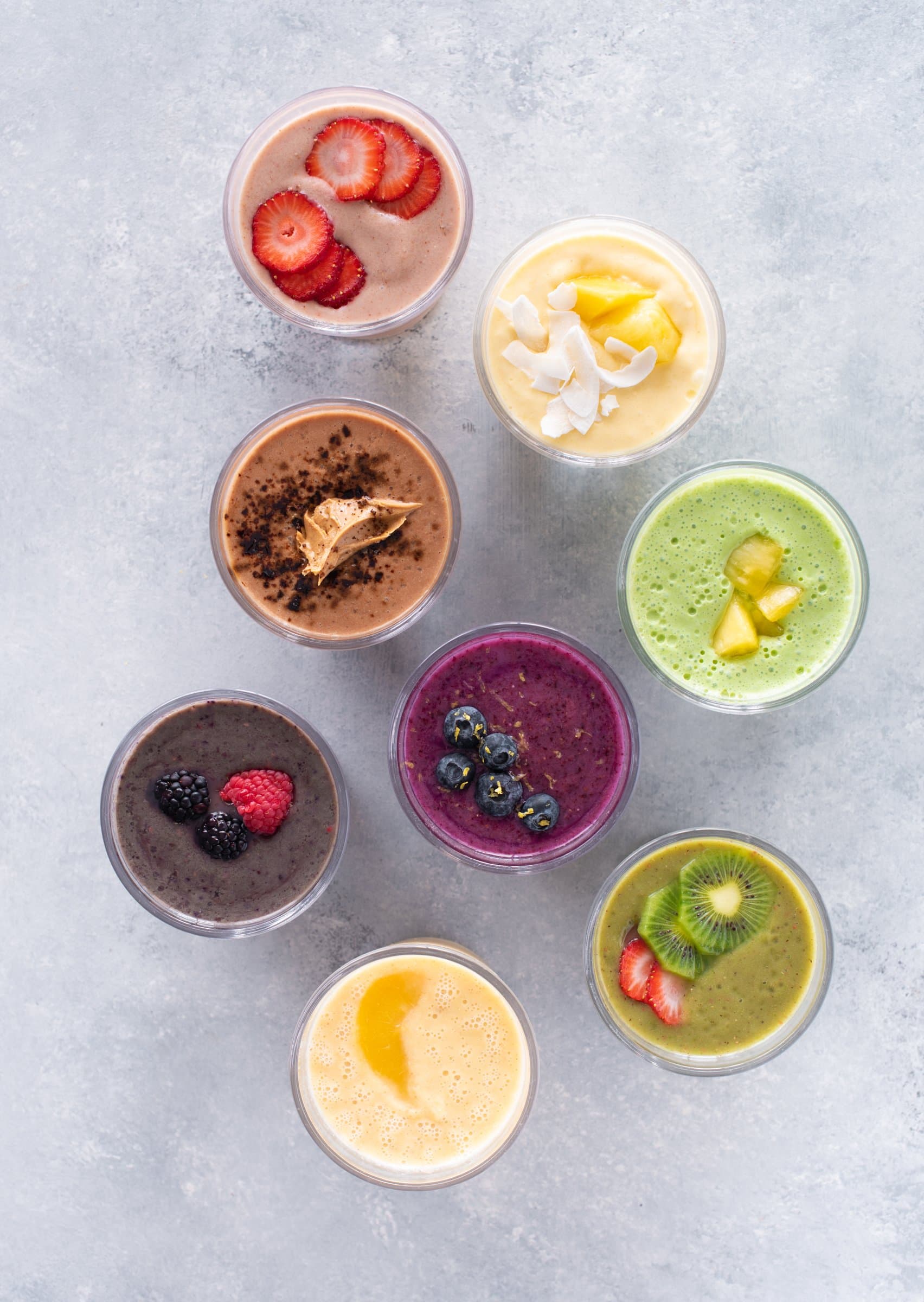 8 Healthy Smoothies Without Banana shown from overhead on a marbled background