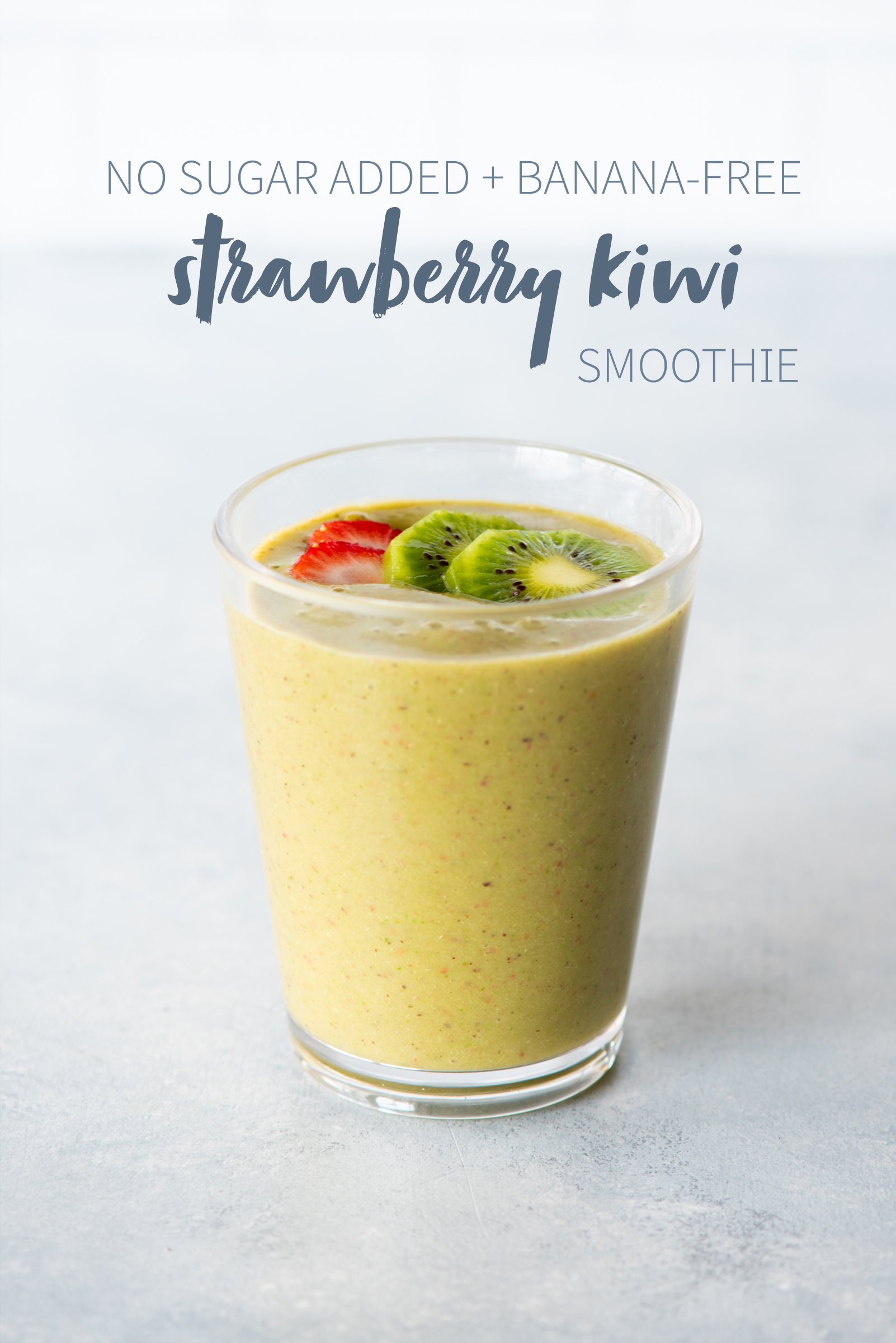 Strawberry kiwi smoothie in a clear glass topped with sliced fruit. A text overlay reads "No Sugar Added + Banana-Free Strawberry Kiwi Smoothie."