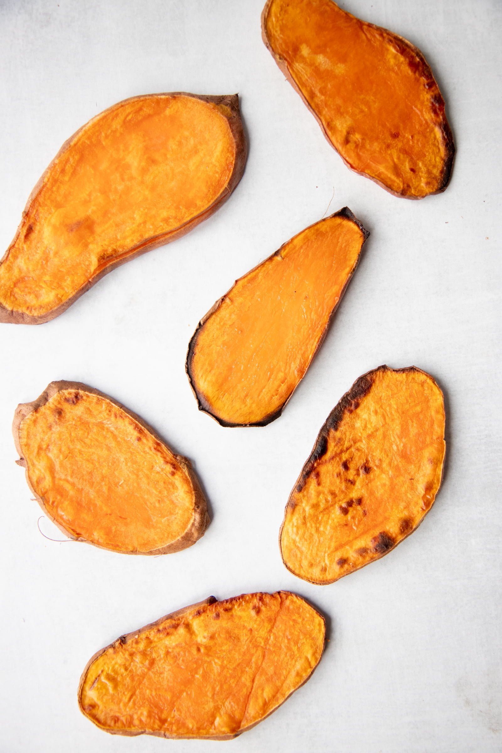 Sweet potato planks toasted and laid out on a white background