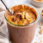 Jar of chocolate peanut butter overnight oats with a spoon in it