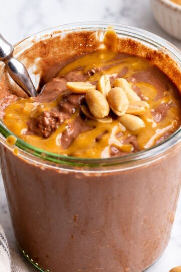 Jar of chocolate peanut butter overnight oats with a spoon in it