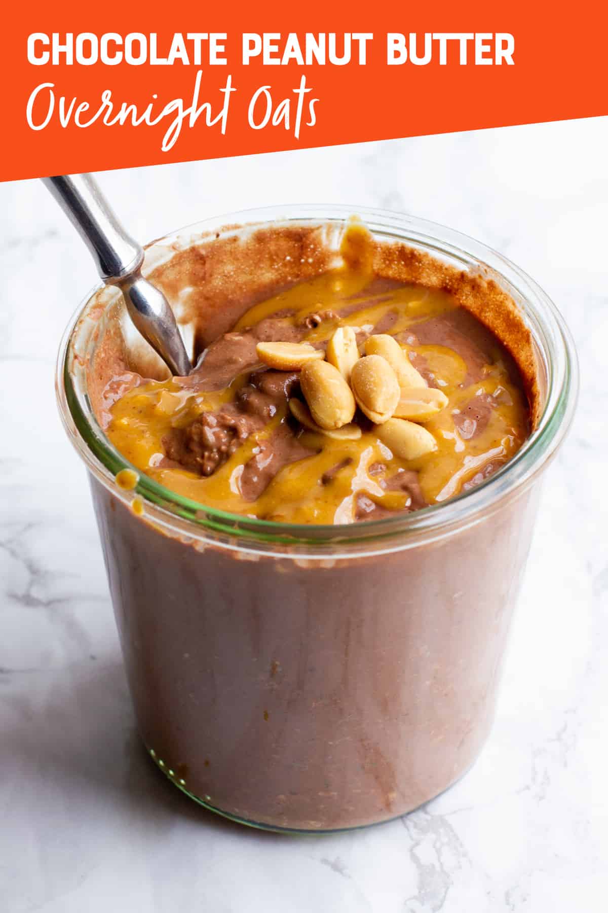 A clear glass jar filled with chocolate peanut butter overnight oats, with a spoon sticking out. A text overlay reads "Chocolate Peanut Butter Overnight Oats."