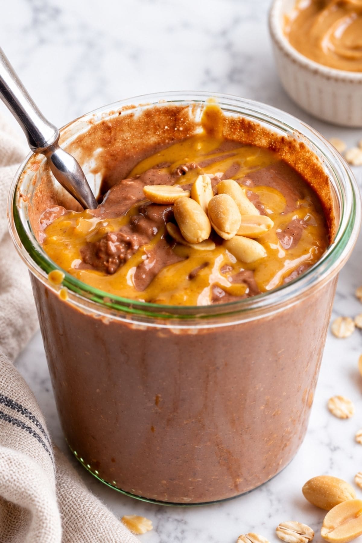 Glass jar of chocolate peanut butter overnight oats with a spoon