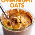 A jar of chocolate peanut butter overnight oats with a spoon with text overlay "Reese's Cup Overnight Oats"