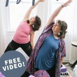 Two brunette women standing on yoga mats in a Reverse Warrior position, practicing some gentle yoga. A text overlay reads "Body Awareness Yoga Practice. Free Video!"