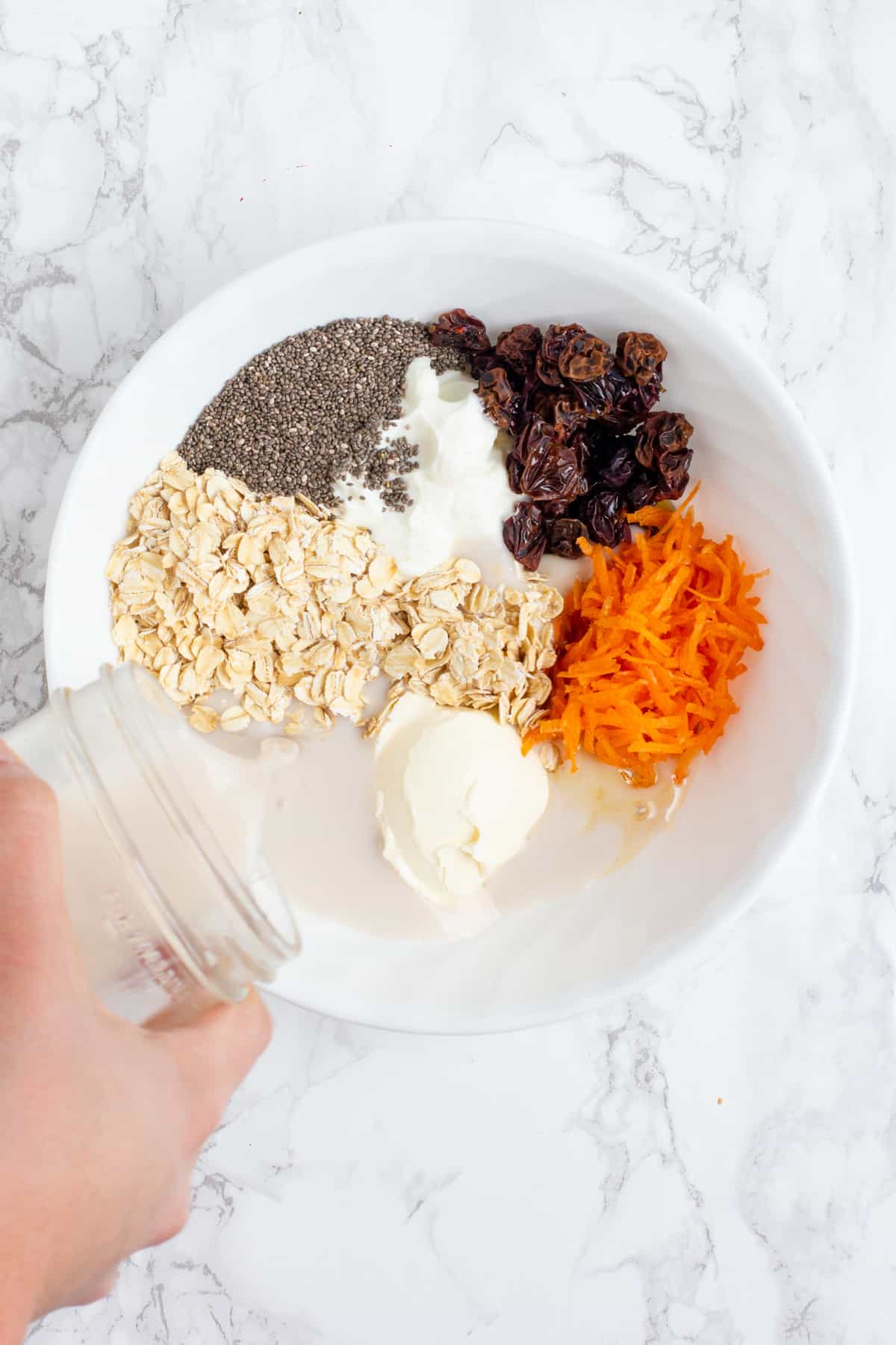 https://wholefully.com/wp-content/uploads/2019/10/mixing-ingredients-carrot-cake-overnight-oats.jpg