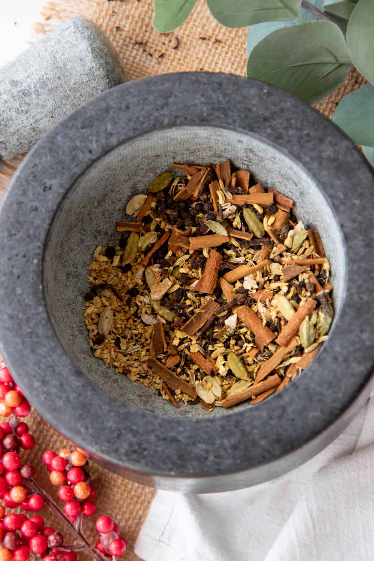 Crushed spices fill a gray mortar, after being crushed with a pestle.