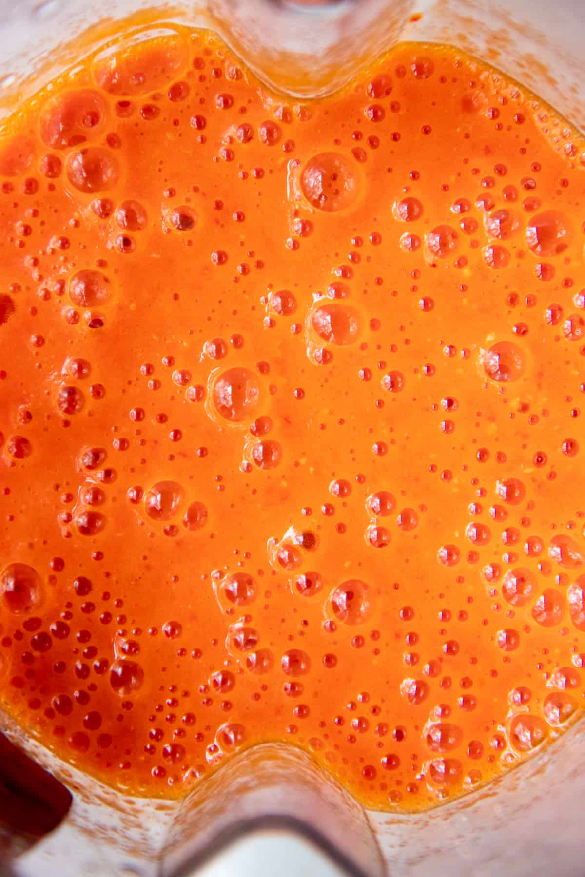 Close up of a bubbly red hot sauce.