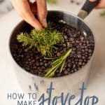 A hand drops pine needles into a small saucepan full of water, rosemary, and juniper berries to make stovetop potpourri. A text overlay reads "How to Make Stovetop Potpourri."
