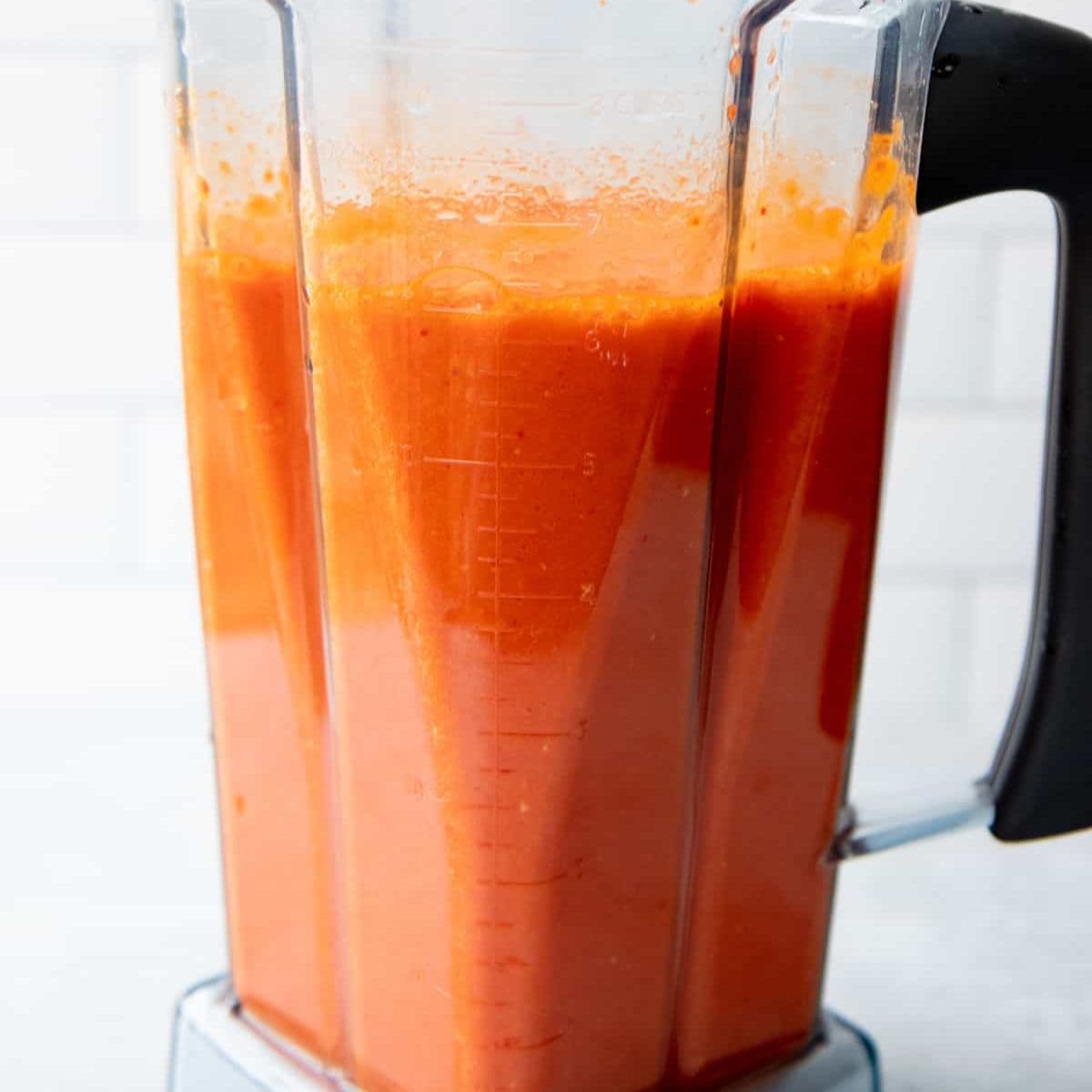 A blender full of smooth, bright red hot sauce