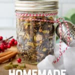 A glass jar filled with loose leaf is tied to a tea ball with baker's twine. The jar is surrounded by spices. A text overlay reads "Easy Holiday Gift! Homemade Chai Gift Set."