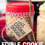 A small jar with a red lid and "Edible Cookie Dough" label is filled with chocolate chip cookie dough. A silver holiday-themed spoon is tied to the jar with red and white baker's twine. A text overlay reads "Edible Cookie Dough Jars."