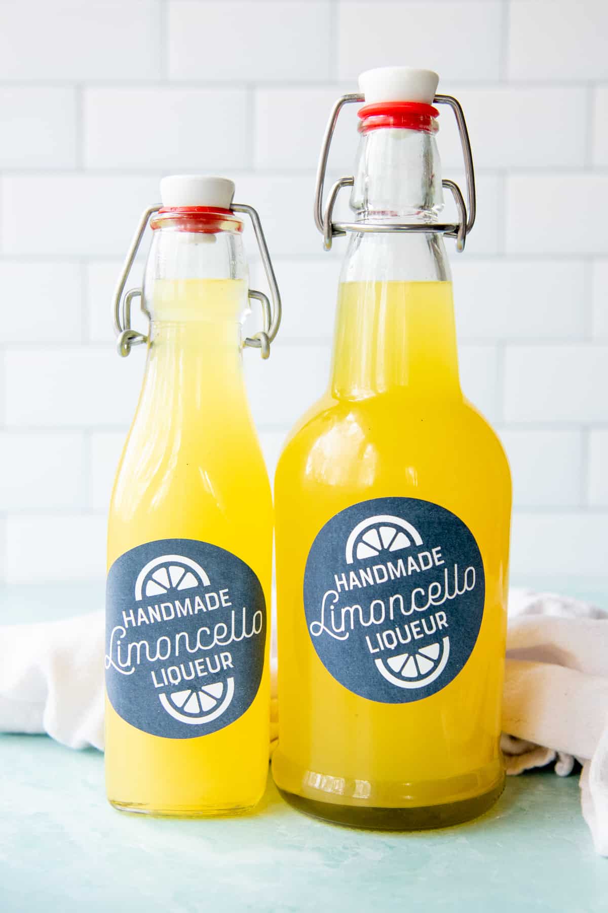 Two different sizes of swing-top bottles, labeled and filled with limoncello.