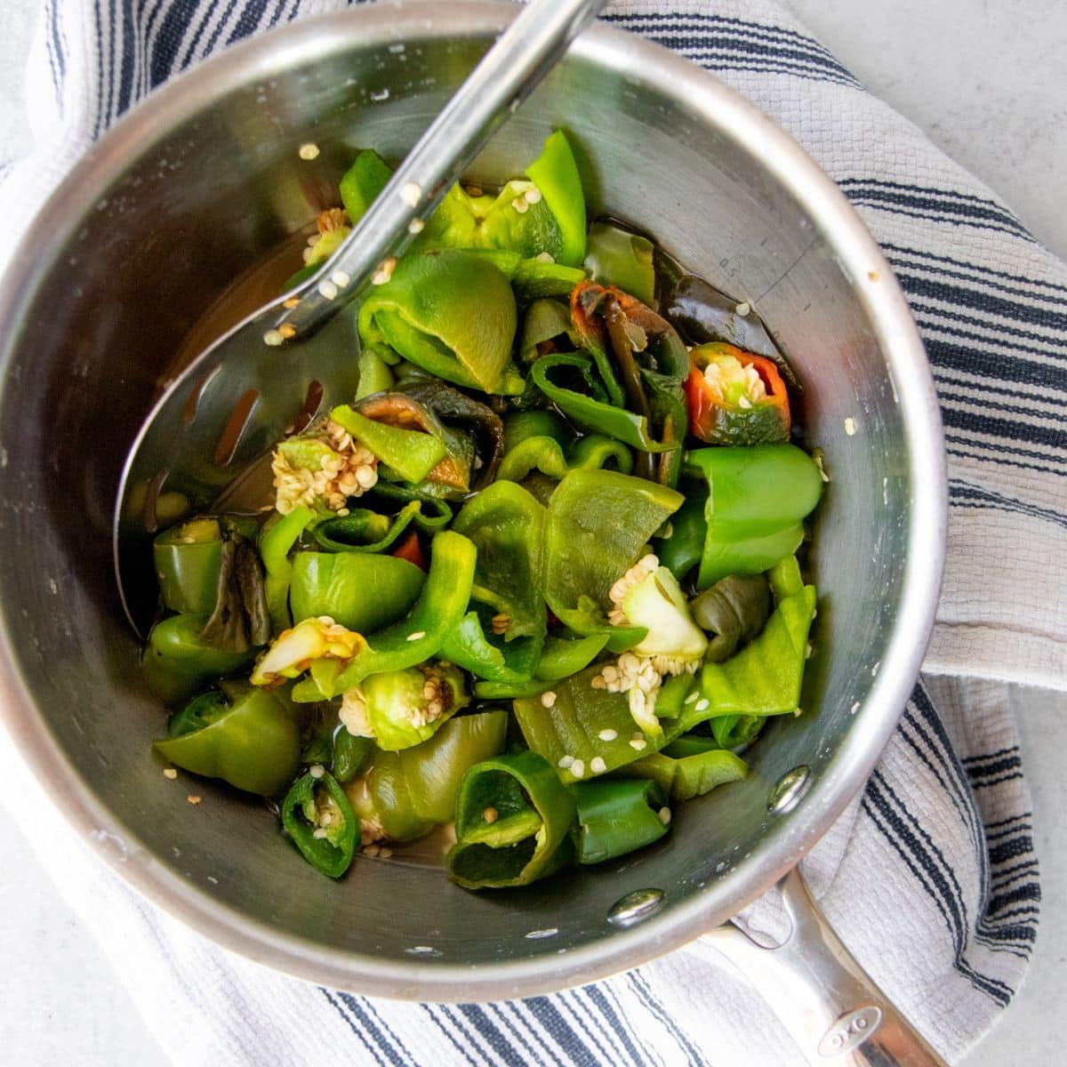 Peppers and garlic in a pot with a metal spoon
