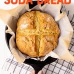 A round loaf of Irish soda bread rests in a cast iron skillet. A hand holds the handle of the pan. Text overlay reads, "easy Irish soda bread."