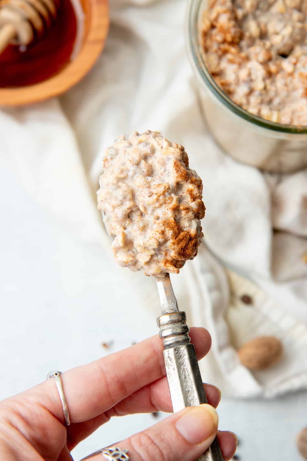 A spoon holds a bite of overnight oatmeal.