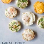 A variety of breakfast egg muffins sit on a gray background. A text overlay reads "Meal Prep Egg Muffins."