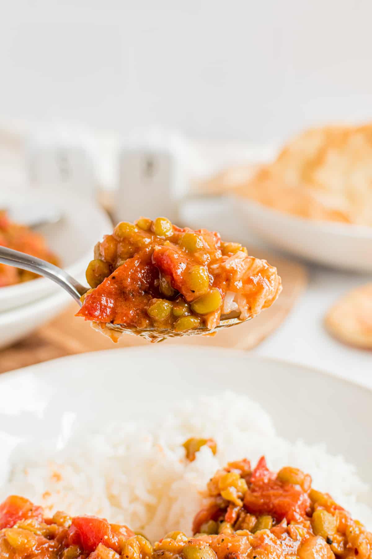 A spoon holds a bite full of Split Pea Curry.