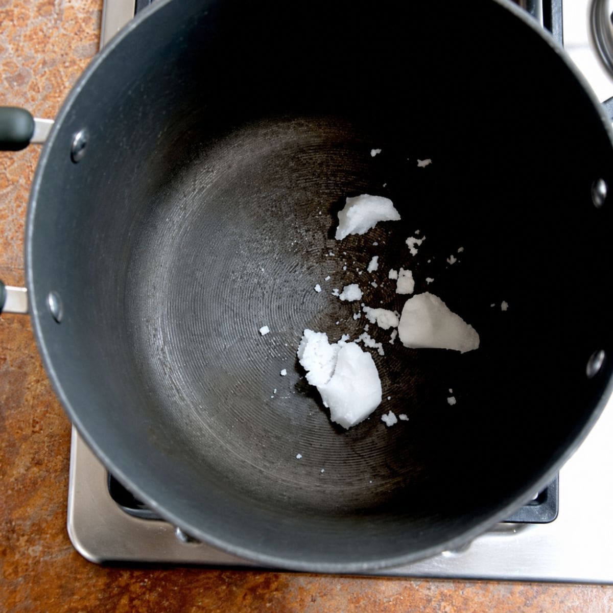 Melting coconut oil in a pot on the stove