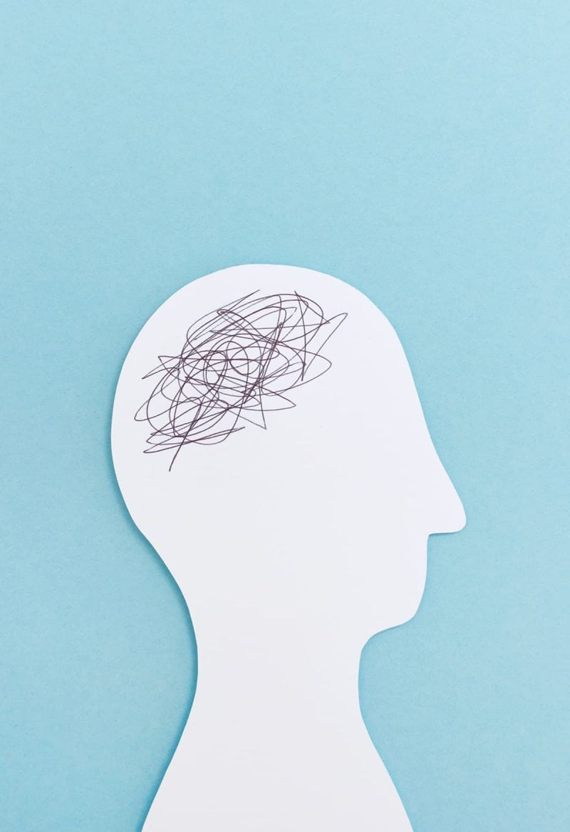 A white paper cut out of a head with scribbles where the brain would be