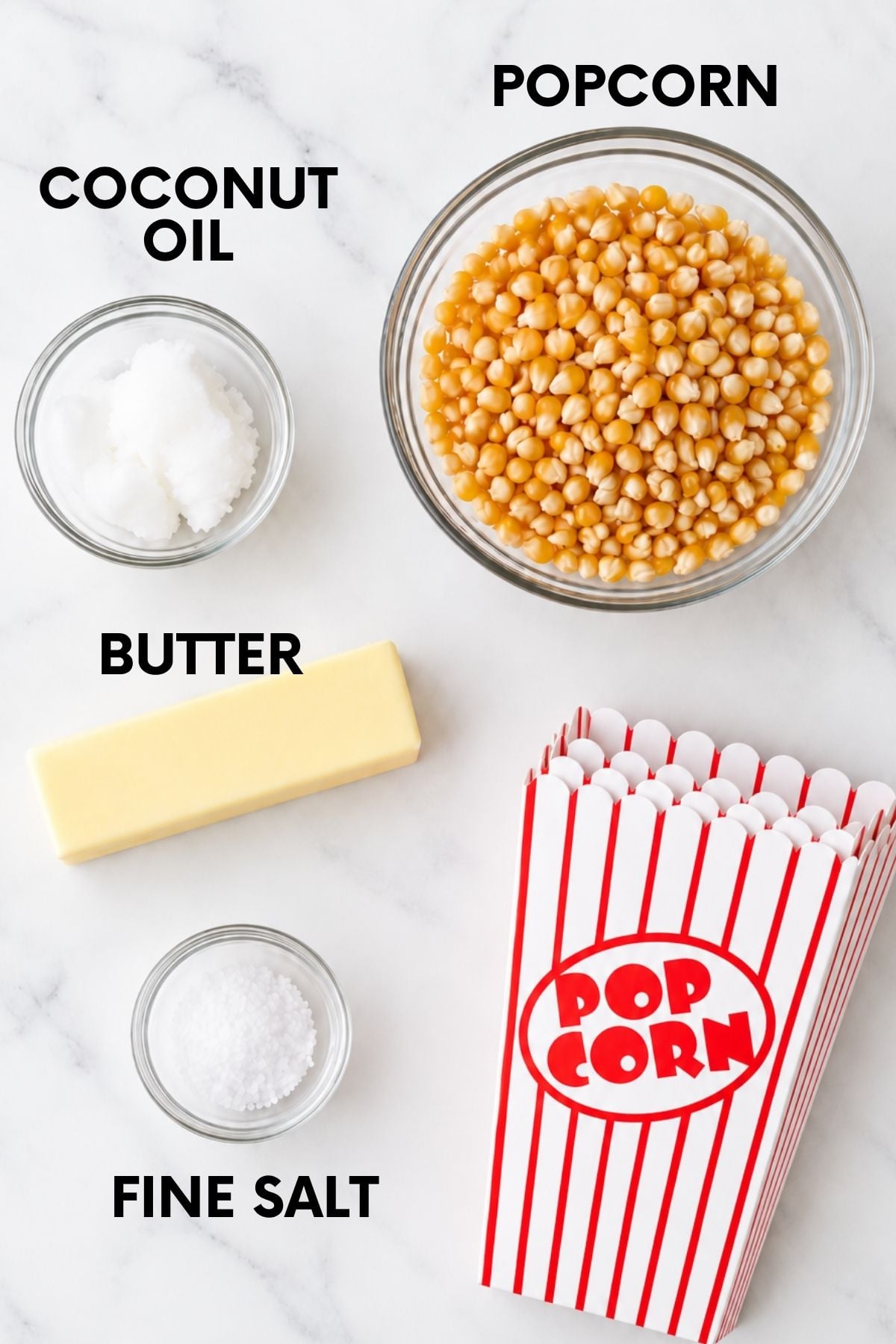 Ingredients for movie theater popcorn on a countertop: coconut oil, popcorn, butter, and salt
