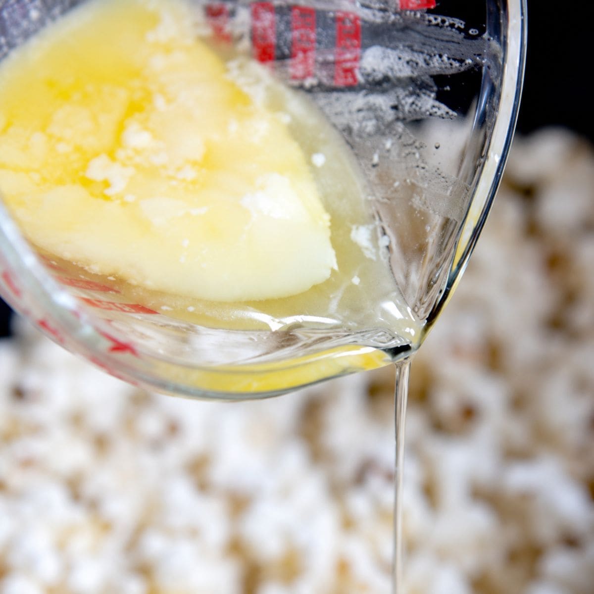 Pouring clarified butter onto popcorn