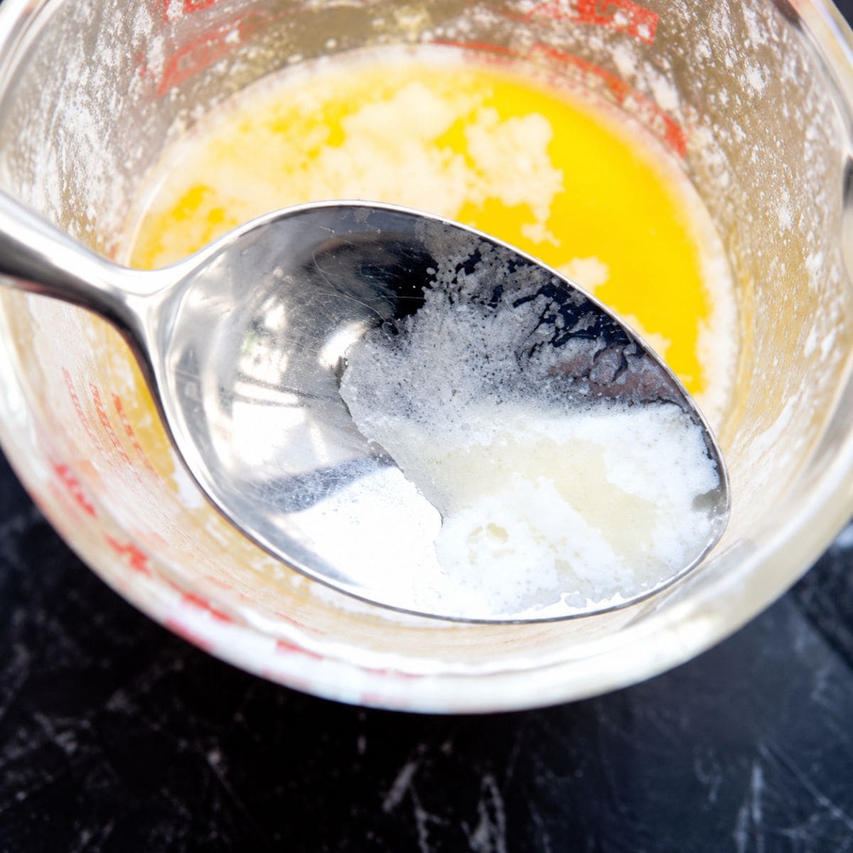 Skimming off milk solids from clarified butter