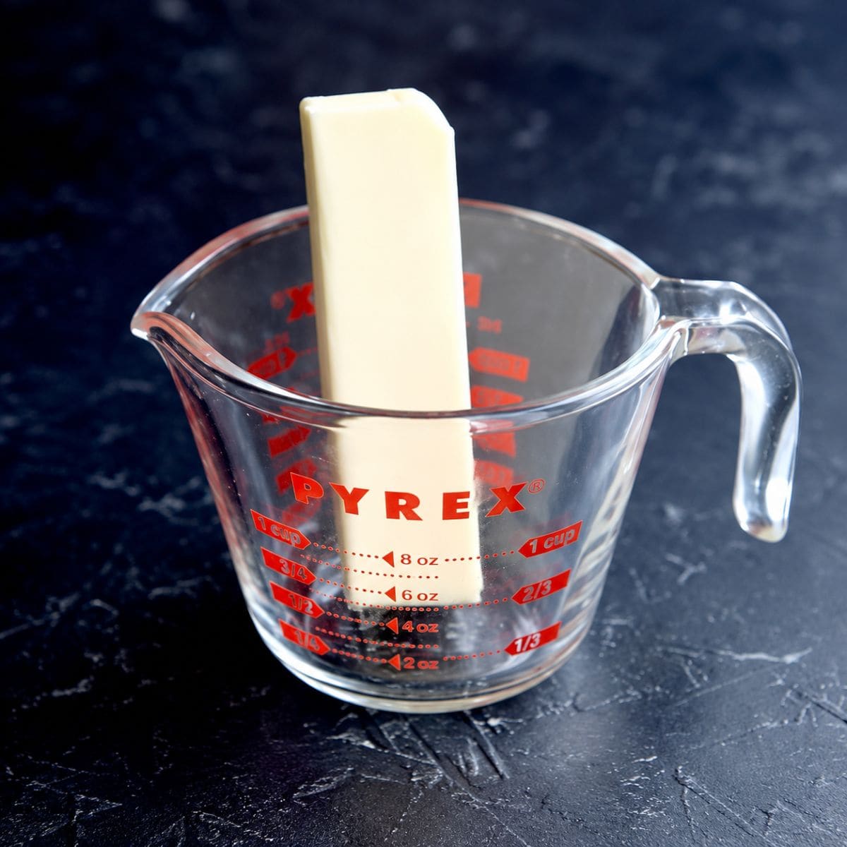 Stick of butter in a glass measuring cup