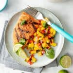 Overhead of plated grilled salmon with mango salsa.