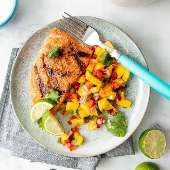 Overhead of plated grilled salmon with mango salsa.