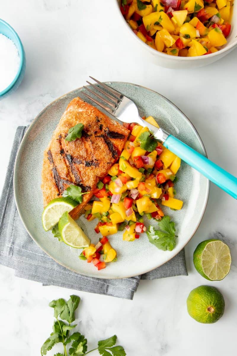 Overhead of plated grilled salmon with mango salsa.
