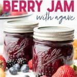 Close-up of two Ball Perfect Mason jars filled with finished mixed berry jam surrounded by fresh berries and biscuits. A text overlay reads "how to Can Naturally Sweetened Berry Jam with Agave."