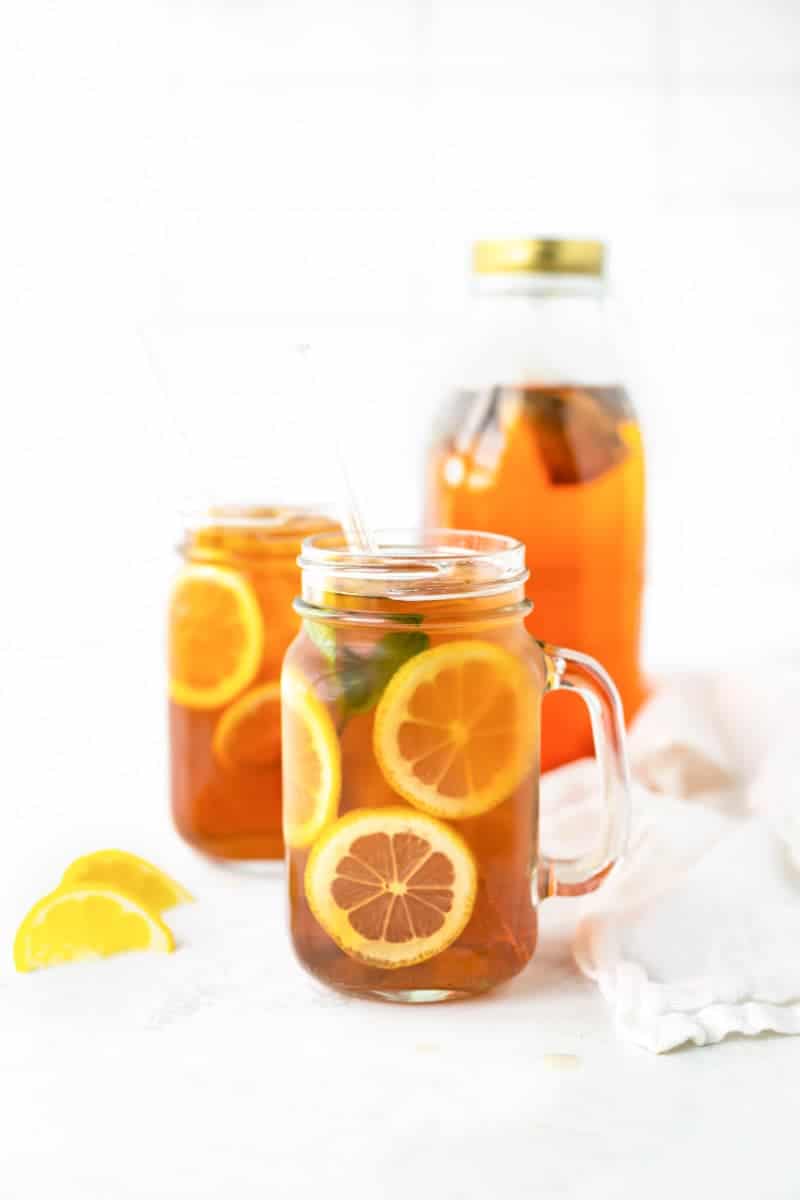 Finished sun tea in mason jar glasses with lemon wheels.