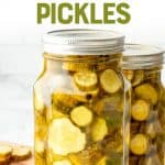 Close-up of full quart jar of canned bread and butter pickles on a wooden cutting board with fresh pickles beside it. A text overlay reads, "The easiest! Bread and Butter Pickles."