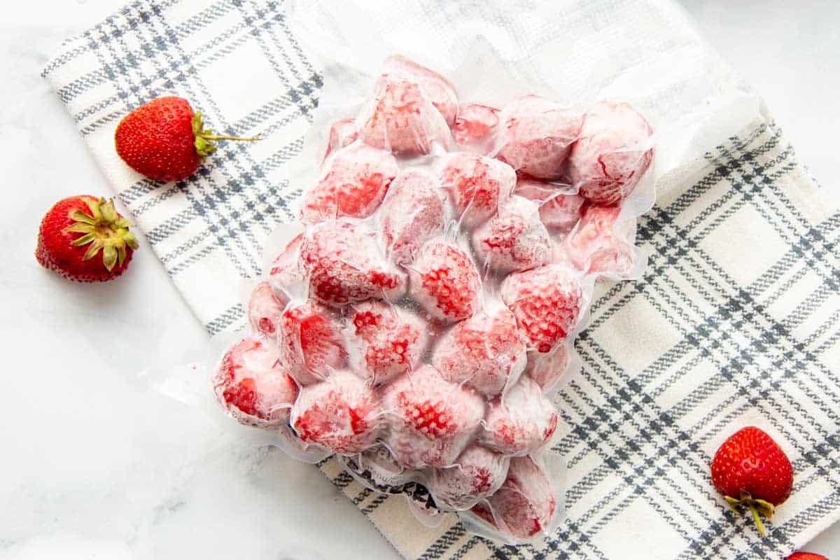 Overhead of frozen strawberries in a vacuum sealed bag.