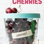 Tall glass container with lid, labeled and filled with individually frozen, pitted cherries. A text overlay reads, "How to Freeze Cherries."
