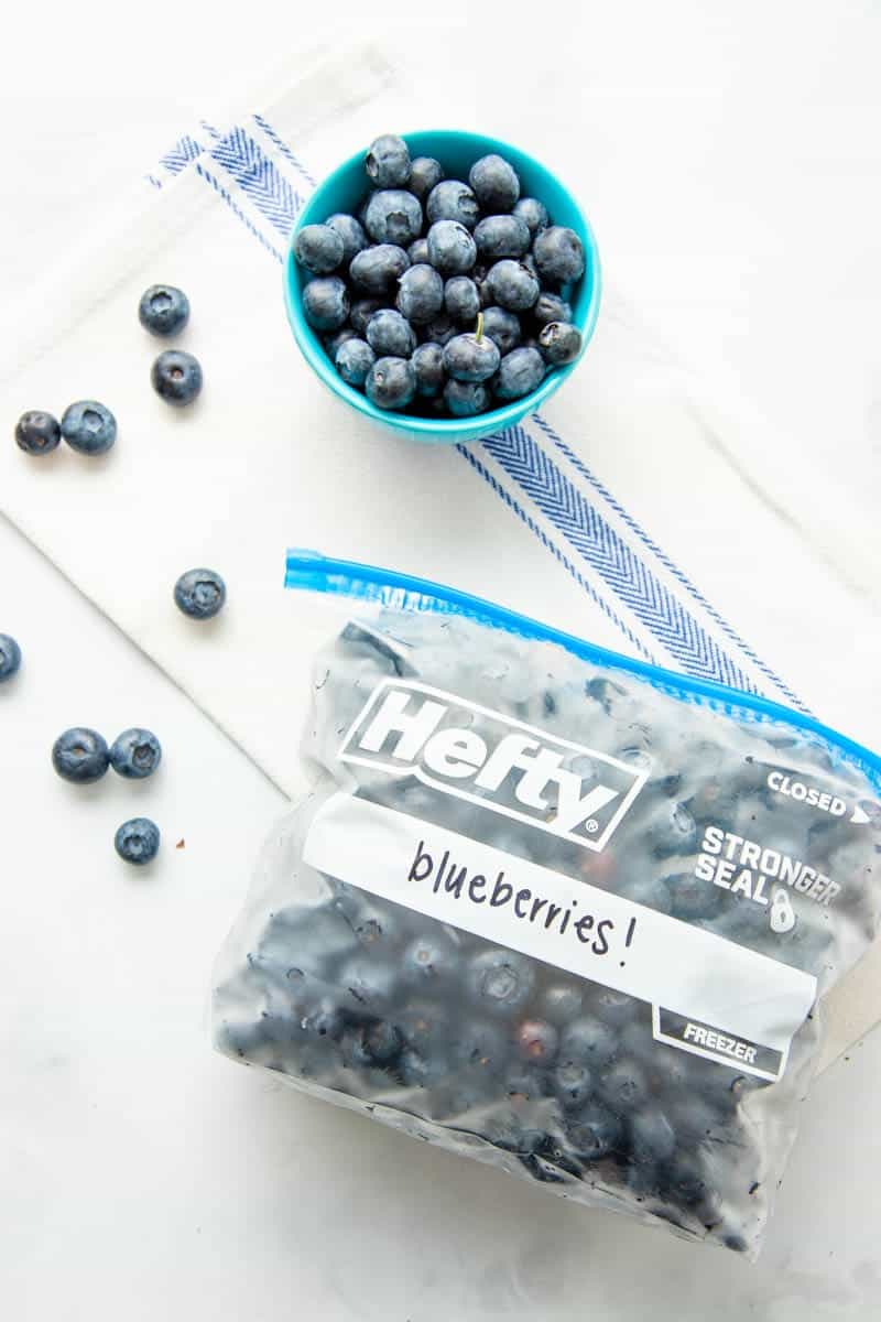 Overhead of Hefty freezer bag filled with individually frozen blueberries labeled and lying on its side.