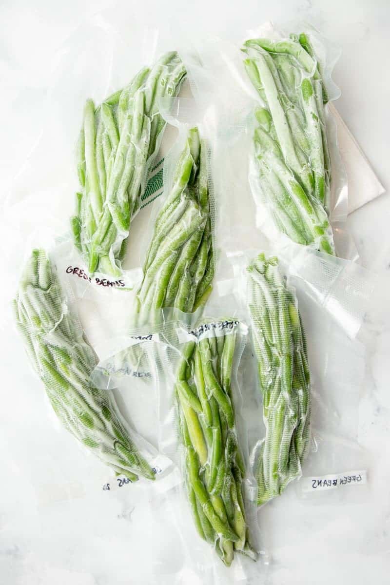 Overhead of frozen vacuum sealed packages of green beans.