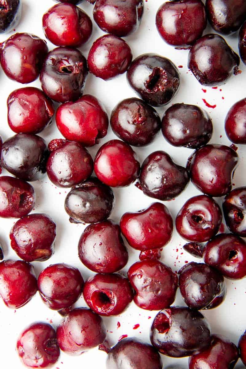 Overhead of fresh, pitted cherries on a baking sheet.