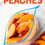 Overhead of open freezer bag filled with individually frozen peach slices. A text overlay reads, "How to Freeze Peaches."