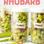Three jars filled with individually frozen pieces of cut rhubarb standing on a kitchen towel. A text overlay reads, "How to Freeze Rhubarb."
