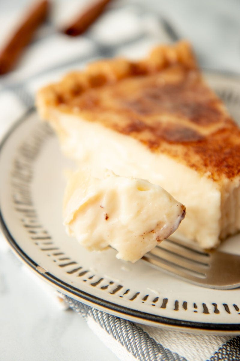 Close-up of a bite of sugar cream pie on a fork.