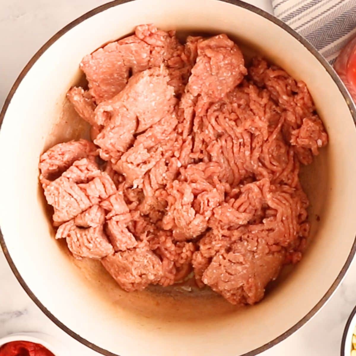 Ground turkey sauteeing in a white Dutch oven