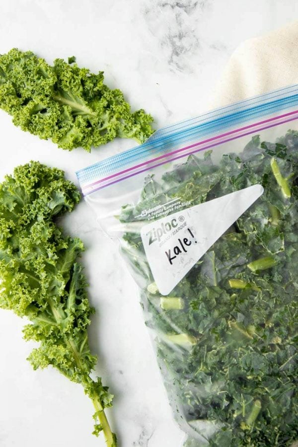 Close-up of frozen kale in a Ziploc freezer bag.
