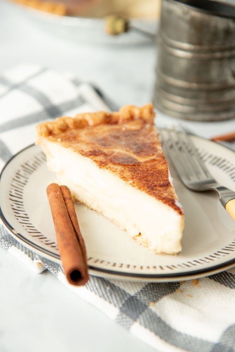 A single slice of old fashioned sugar cream pie sits on a plate.