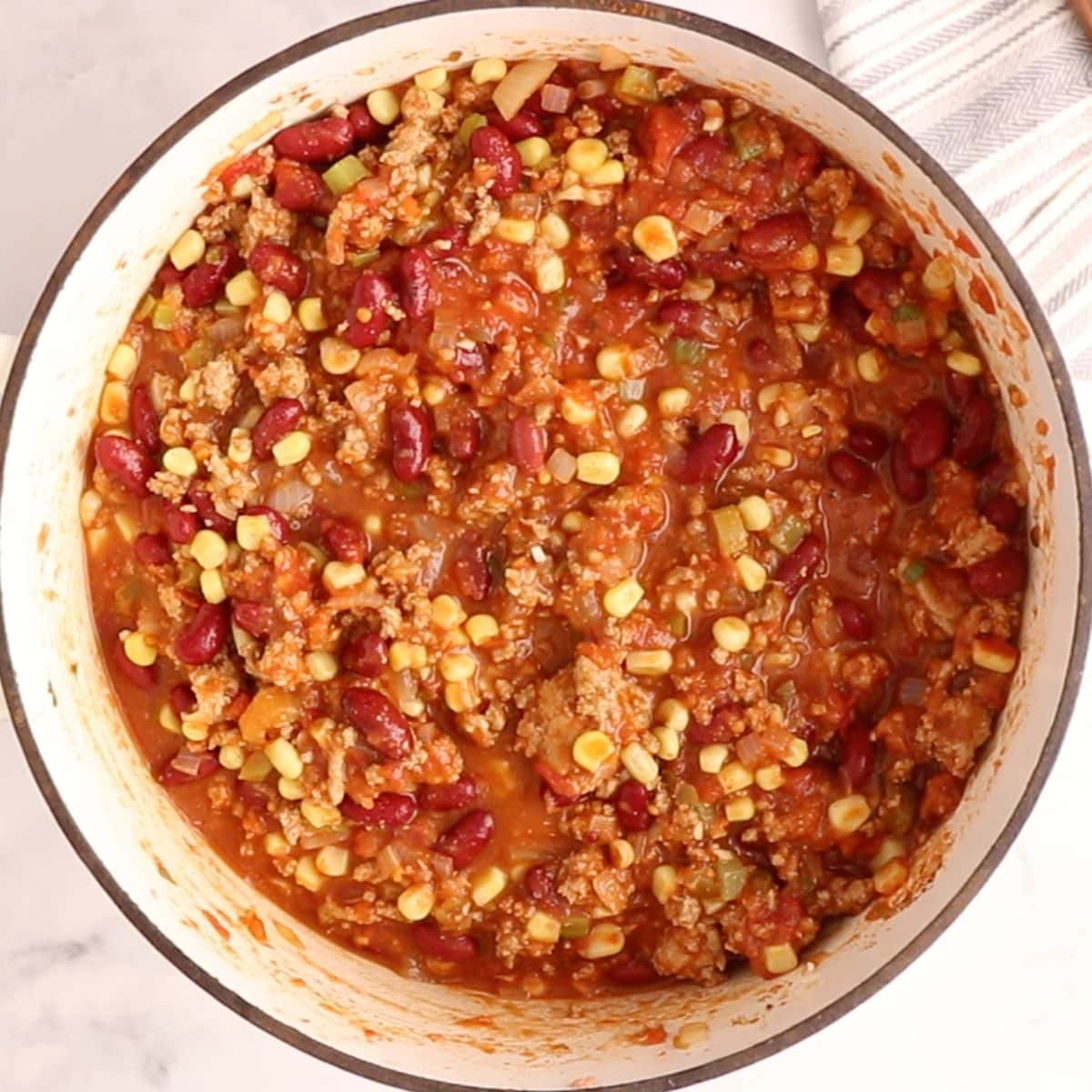 Taco chili simmering in a white Dutch oven